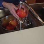 washing fruit under running water