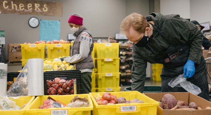 Food bank workers pack vegetables in bins